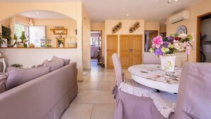 A cozy living area with a sofa set, a dining table with chairs, and a chandelier. - Spacieux Appartement L Instant Mediterranee (Cers)