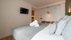 Et hotelværelse med seng, fjernsyn, et lille bord og en stol.