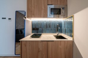 Eine kompakte Küche mit Mikrowelle, Spüle und integriertem Backofen.