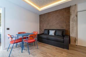 Ein modernes Wohnzimmer mit einer Couch, Sesseln, einem Tisch und einer Wand mit Muster.