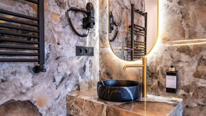 A bathroom with a marble sink, a handheld hair dryer, and a bottle of hand soap. - Sol Atelier | Apartments by Monaro* * * * * (Madrid)