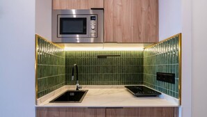 A compact kitchen with a microwave, a sink, and a stovetop. - Sol Atelier | Apartments by Monaro* * * * * (Madrid)