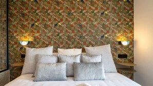 A hotel room with a large bed, multiple pillows, and two wall-mounted lamps. - Sol Atelier | Apartments by Monaro* * * * * (Madrid)