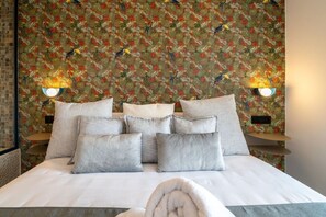 A hotel room with a large bed, multiple pillows, and two wall-mounted lamps. - Sol Atelier | Apartments by Monaro* * * * * (Madrid)
