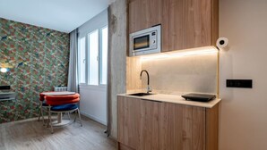 A compact kitchen with a microwave, sink, and countertop. - Sol Atelier | Apartments by Monaro* * * * * (Madrid)