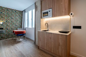 A compact kitchen with a microwave, sink, and countertop. - Sol Atelier | Apartments by Monaro* * * * * (Madrid)