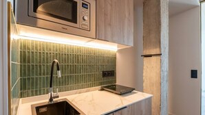 A kitchenette with a microwave, a sink, and a digital scale. - Sol Atelier | Apartments by Monaro* * * * * (Madrid)