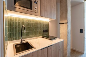 A kitchenette with a microwave, a sink, and a digital scale. - Sol Atelier | Apartments by Monaro* * * * * (Madrid)