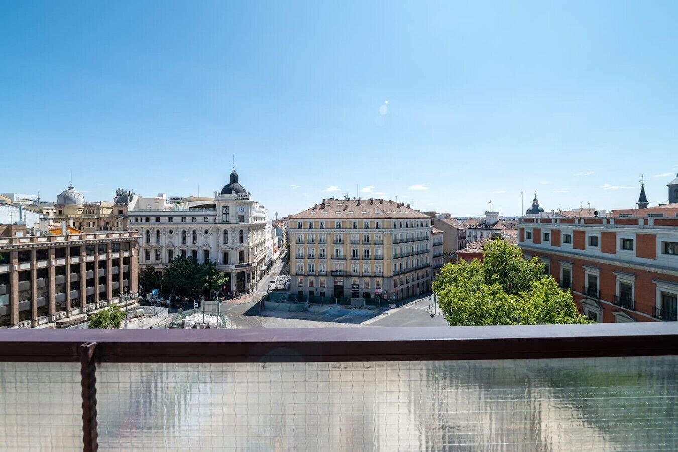Eine Stadtansicht mit einem markanten Gebäude, das eine Kuppel und eine Theaterschilderung zeigt.