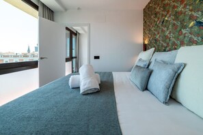 A hotel room with a bed, a window, and a door leading to another room. - Sol Atelier | Apartments by Monaro* * * * * (Madrid)