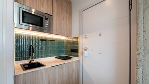 A compact kitchen with a microwave, a sink, and a countertop. - Sol Atelier | Apartments by Monaro* * * * * (Madrid)