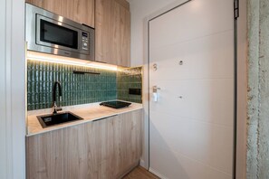 A compact kitchen with a microwave, a sink, and a countertop. - Sol Atelier | Apartments by Monaro* * * * * (Madrid)