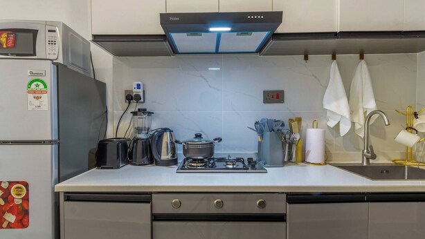 Une cuisine moderne équipée d’un four à micro-ondes, d’un grille-pain, d’une bouilloire et d’une cuisinière à gaz.