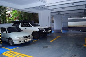 Eine Parkgarage mit zwei Autos, markierten Parkplätzen und einem blauen Boden.