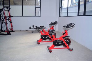A gym with stationary bikes and weight machines. - Cozy Nest 1BR Kilimani (Nairobi)