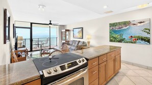 A modern kitchen with a gas stove, wooden cabinets, and a large island. - New Listing Oceanview Guaranteed (Lahaina)