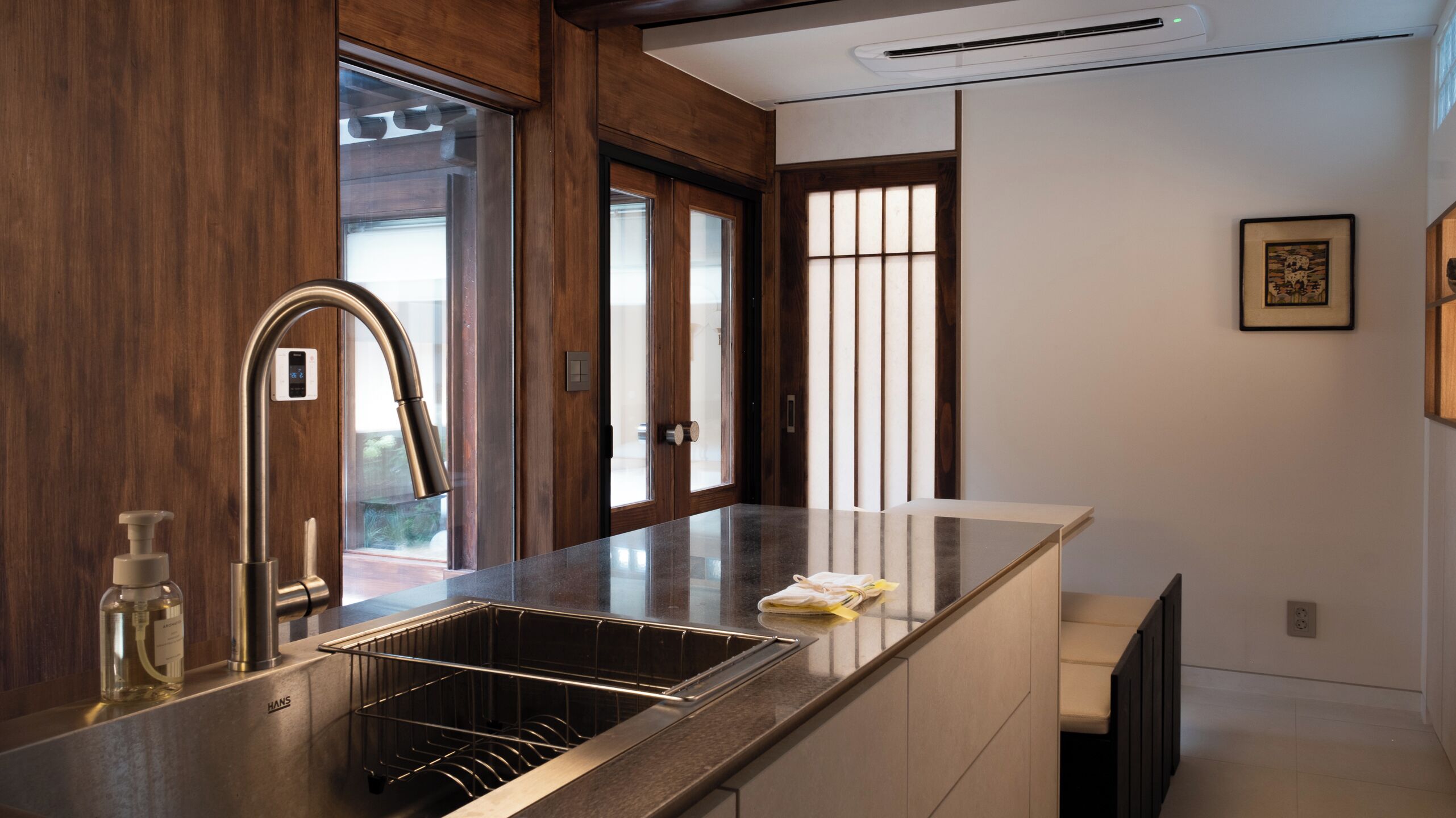 A modern kitchen with a stainless steel sink, a built-in dishwasher, and wooden cabinetry.
