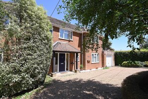 A two-story brick house with a front door, a garage, and a driveway. - Milcourt -  a managed house that sleeps 8 guests  in 4 bedrooms (Canterbury)