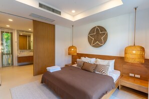 A modern bedroom with a large bed, a star wall decoration, and a hanging light fixture. - Private Pool Villa in the Heart of Bang Tao (ต.เทพกระษัตรีย์)