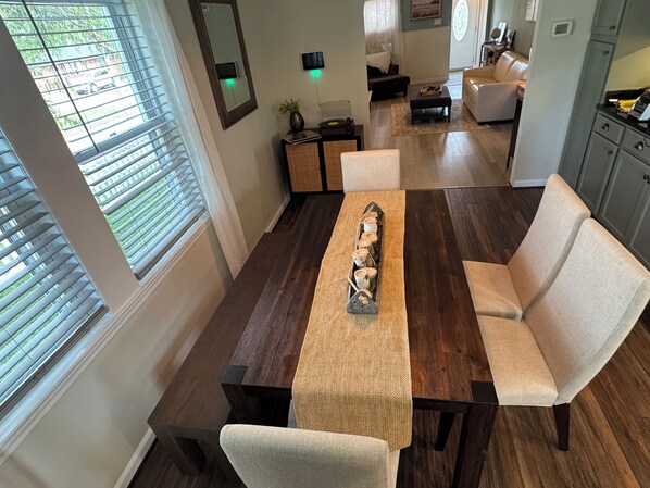 A dining area with a wooden table, cushioned chairs, and a decorative centerpiece.