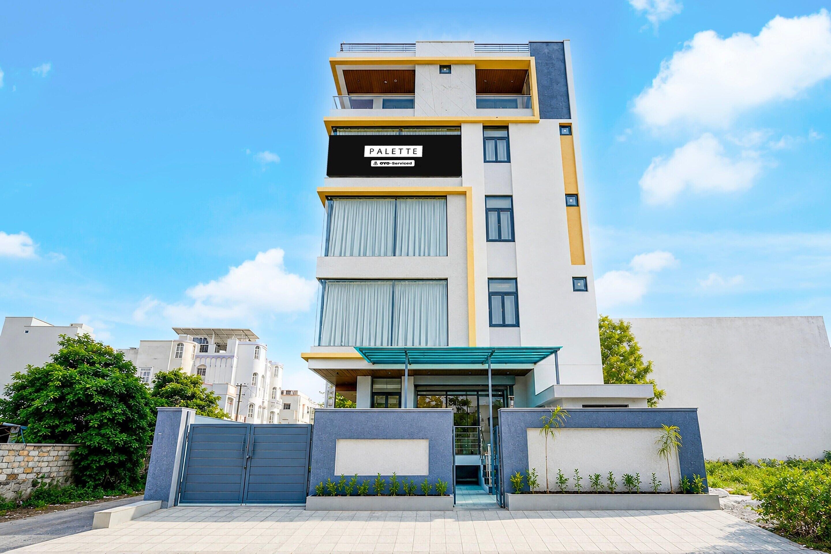 A multi-story residential building with a sign indicating 'PALETTE' and 'OYO-Serviced' on the facade.