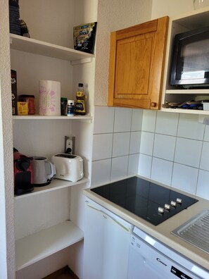 Eine kleine Küche mit Mikrowelle, Toaster und kleinem Kühlschrank.