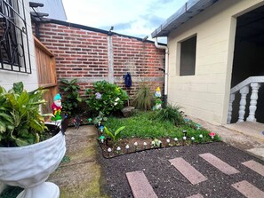 Ein Garten mit Blumentöpfen und einer kleinen, dekorativen Gartenanlage mit trittfesten Pflastersteinen.