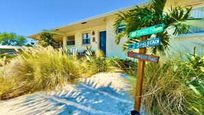 A beachfront property with a signpost indicating directions to Peanut Island, Juno Beach Pier, and Ocean Reef Park. - Rent The Crafty Mermaid, 2-bedroom house, yard, near Blue Heron dive area (West Palm Beach)