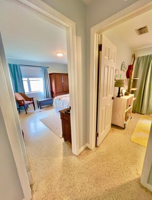 A bedroom with a bed, a dresser, a chair, and a window with curtains. - Rent The Crafty Mermaid, 2-bedroom house, yard, near Blue Heron dive area (West Palm Beach)