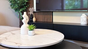 Une table ronde en marbre, ornée d’une plante en pot et d’objets décoratifs.