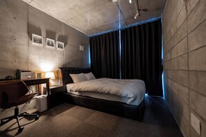 A modern hotel room with a bed, desk, chair, and a view of the outside. - cerisier villa Yomitan (Yomitan)