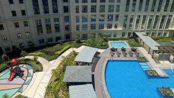 A residential building with a swimming pool, a children's play area, and a landscaped garden.