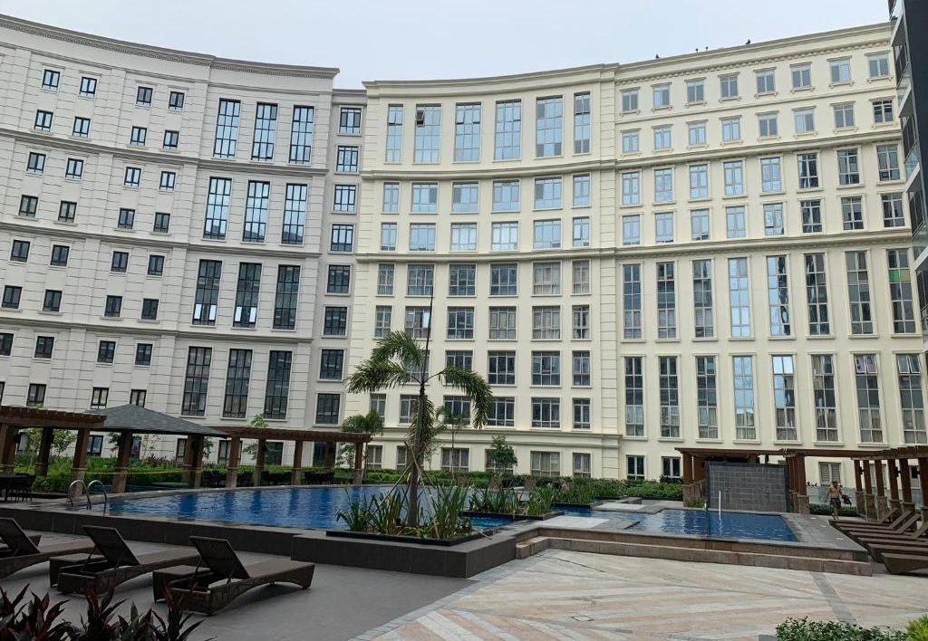 A hotel with a swimming pool, multiple floors, and a modern architectural design.