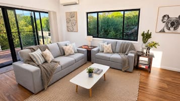 A modern living room with a grey sectional sofa, a coffee table, and a small side table.