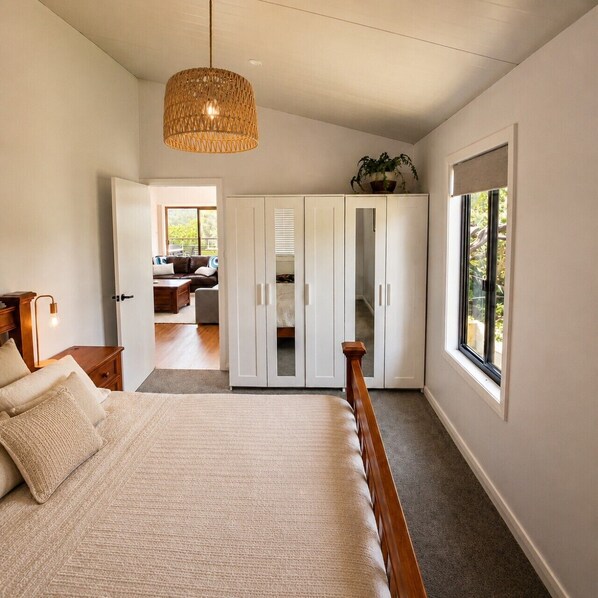 A bedroom with a bed, wardrobe, and a window.