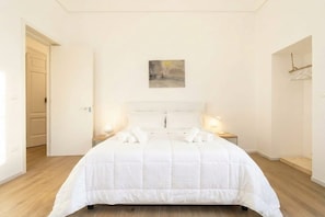 Ein Schlafzimmer mit einem großen Bett, Nachttischlampen und einem Bild an der Wand.