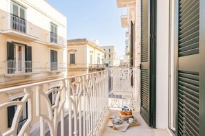 A narrow balcony with a white railing, a small table with a basket of bread, and a window with shutters. - Casa del Barone – Elegant 3-Bedroom Retreat in Monopoli (Monopoli)