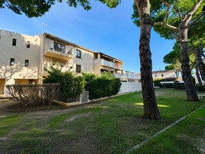 A residential building with multiple balconies, a well-maintained lawn, and mature trees. - Air-conditioned apartment, 2 beautiful bedrooms, Beach 10 min walk, Parking (Saint-Cyr-sur-Mer)