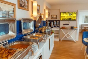 A buffet area with various food containers and a television mounted on the wall. - Orbi City 2-bedroom apartment in Batumi with air conditioning (Batumi)
