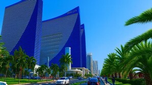 A modern building with the sign 'ORBI CITY' on top, surrounded by palm trees and a clear sky. - Orbi City 2-bedroom apartment in Batumi with air conditioning (Batumi)