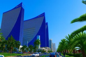 A modern building with the sign 'ORBI CITY' on top, surrounded by palm trees and a clear sky. - Orbi City 2-bedroom apartment in Batumi with air conditioning (Batumi)