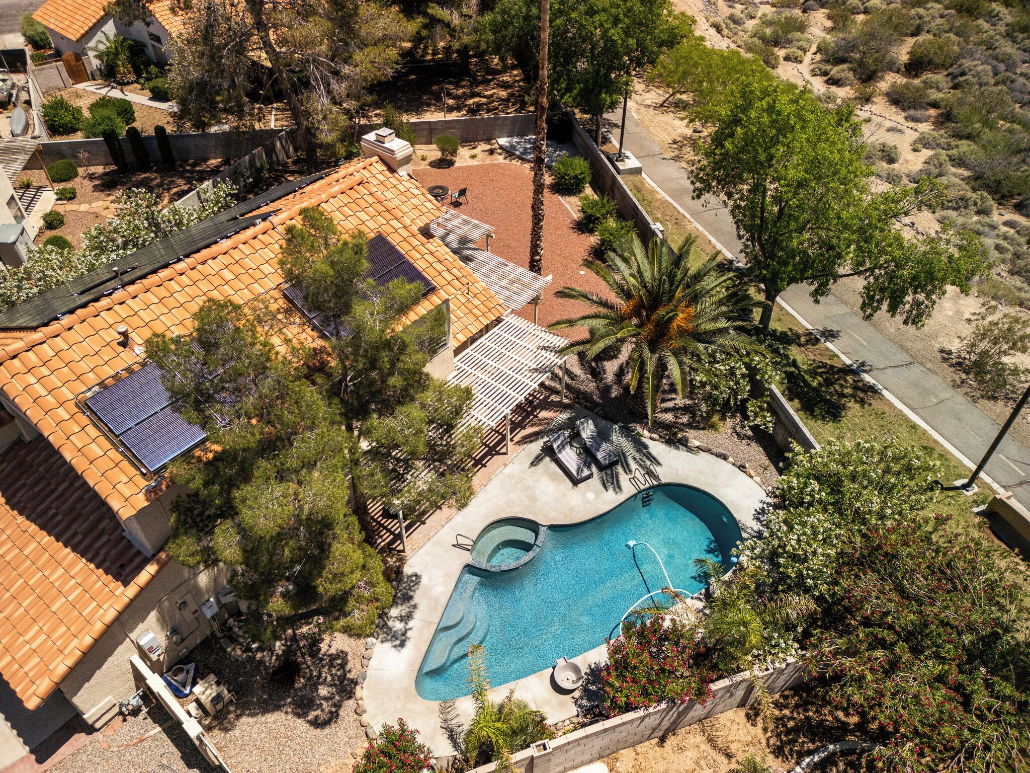 Une propriété résidentielle dotée d’une piscine, de panneaux solaires et d’un jardin clôturé.