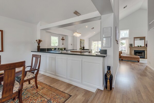 A spacious kitchen with a central island, white cabinetry, and a chandelier. - Main Level Primary Suite PRIVATE Mtn View Yard,
Pool Spa Firepit BBQ 15 mn Strip (Henderson)