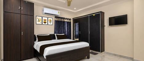 A bedroom with a bed, wardrobe, ceiling fan, air conditioning unit, and a TV.