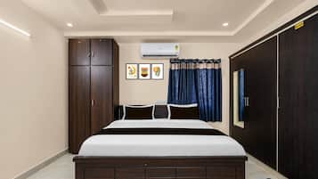 Un dormitorio con cama, armario, equipo de aire acondicionado y cortina.