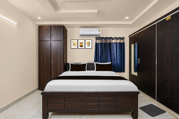 A bedroom with a bed, wardrobe, air conditioning unit, and a curtain.