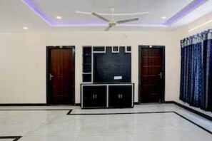 A room with a ceiling fan, a black cabinet, and two doors.