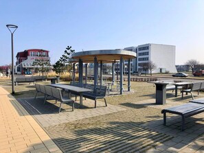 An outdoor seating area with benches and a central gazebo. - Ferienwohnung in Fehmarn-burgtiefe (Fehmarn)