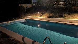 A swimming pool with clear water, a metal ladder, and a light post in the background. - Villa Liliana: Your Private Oasis with a Pool (Stintino)