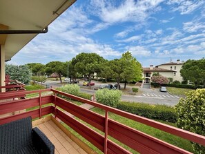 A balcony with a red railing overlooking a street with parked cars and trees. - Fritz Three-room apartment kitchen+terraces, Virgilio spa area, 5 minutes from Bremen beach (Sirmione)